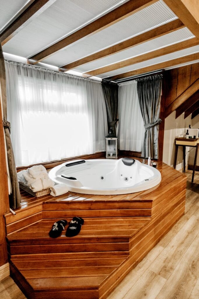 Elegant indoor spa featuring a modern wooden bathtub with luxurious amenities, perfect for relaxation.